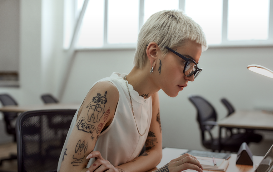 woman sitting at a desk looking at a laptop