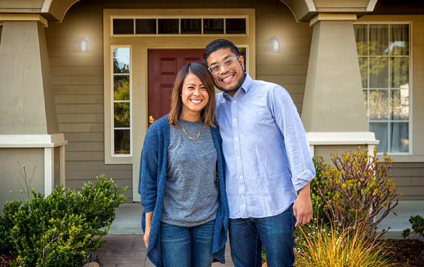 happy couple in front of new home