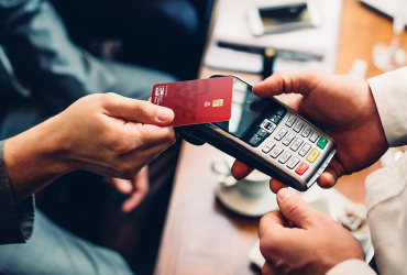 man tapping credit card on card reader