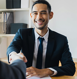 business man in suit shaking hands with another person