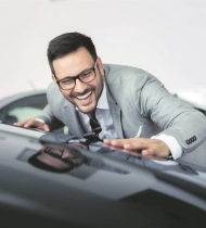 man smiling looking at a car