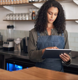 woman in a coffee shop looking at a tablet